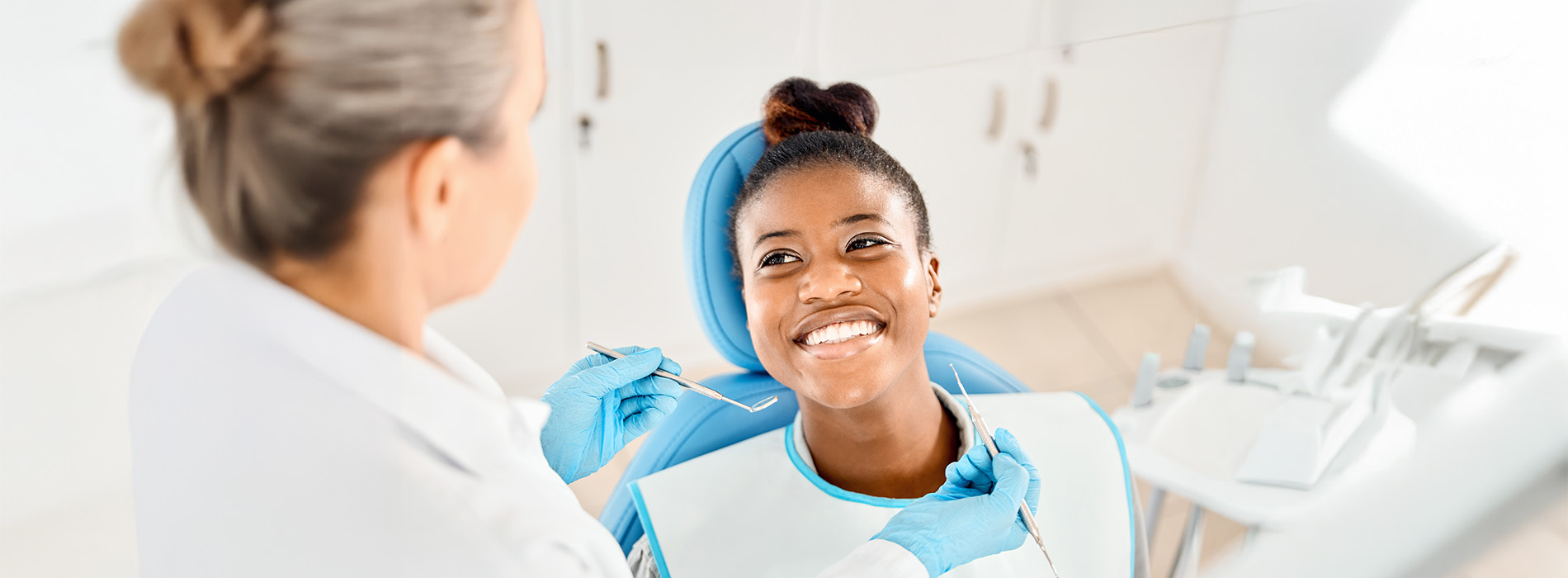 A dental professional assisting a patient during a dental appointment.