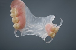 The image shows a transparent 3D model of a human mouth with teeth and gums, placed against a dark background.